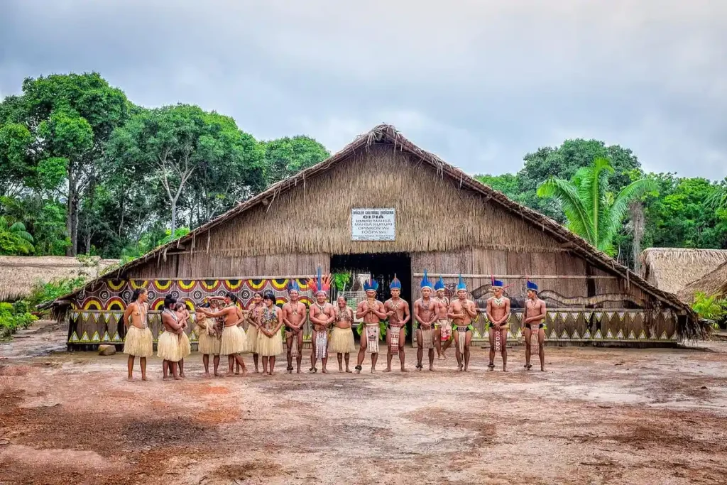 Indigenous Amazon village with traditional wooden huts surrounded by forest
