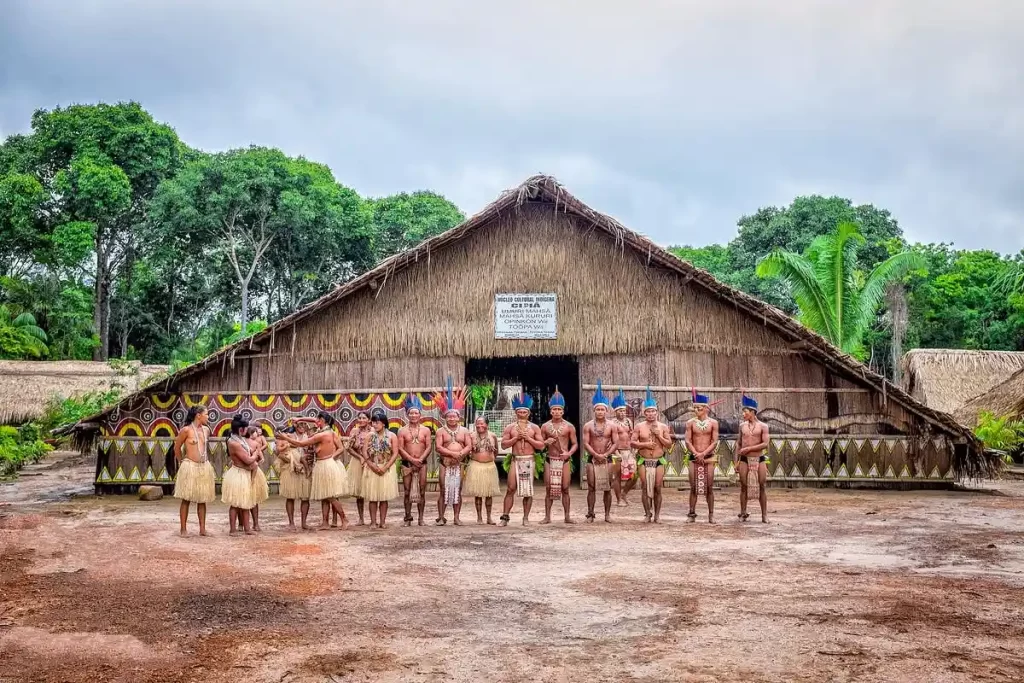Indigenous Amazon village with traditional wooden huts surrounded by forest