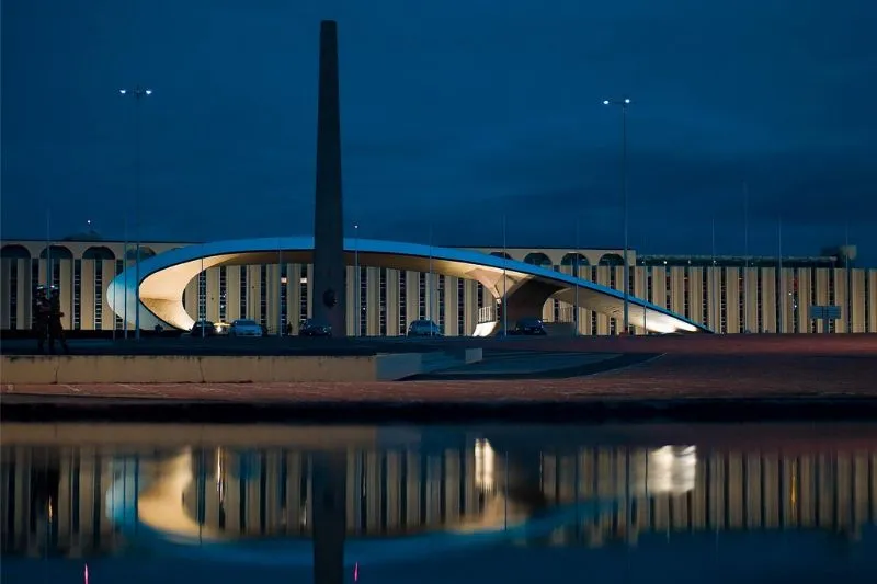 Geometric concrete sculptures resembling crystals in a water mirror at the Crystal Square at night